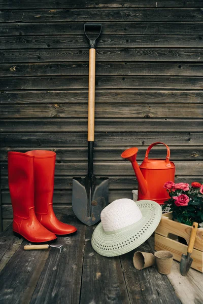 Spade, vattning kan, hatt, gummistövlar, Box av blommor, handskar och trädgårdsredskap — Stockfoto