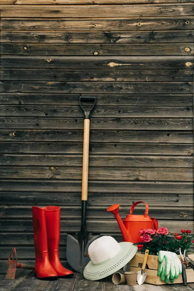 Shovel, watering can, hat, rubber boots, box of flowers, gloves and garden tools — Stock Photo, Image