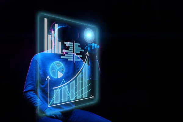 Man uses a virtual reality headset to work with data in the form of graphs and charts. — Stock Photo, Image