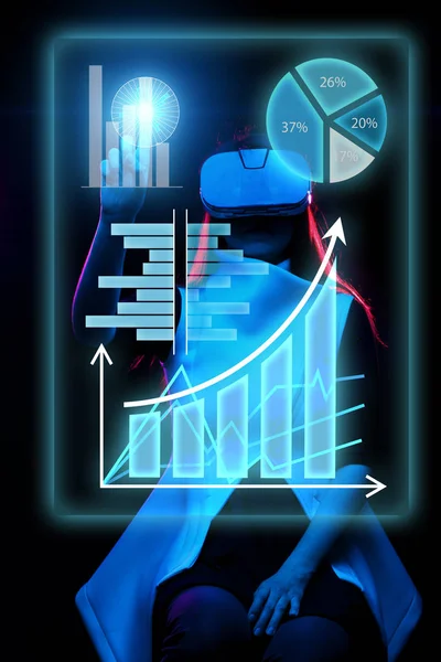 Woman uses a virtual reality headset to work with data in the form of graphs and charts. — Stock Photo, Image