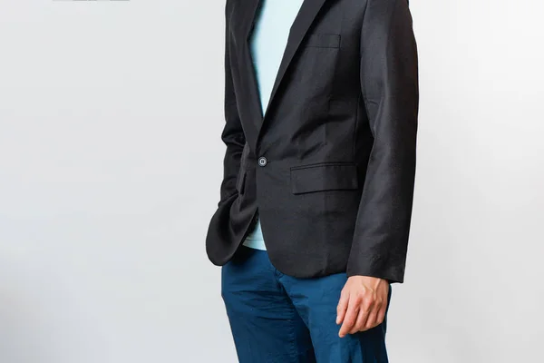 Обрезанное изображение мужчины в футболке, брюках и черной куртке. Портрет современного бизнесмена . — стоковое фото