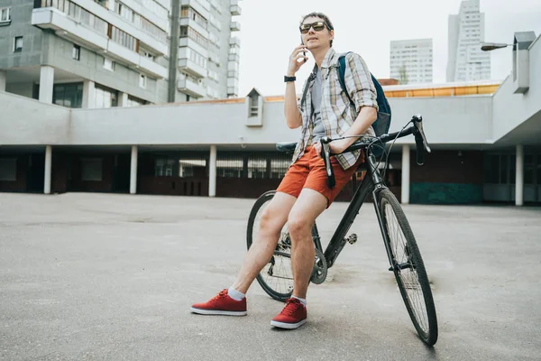 Homem posando ao lado de sua bicicleta . — Fotografia de Stock