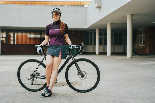 Mulher posando ao lado de sua bicicleta . — Fotografia de Stock