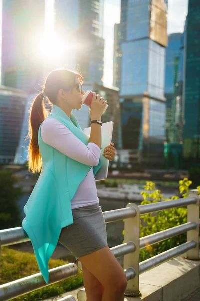 Portrait of business woman walking with laptop and cup of coffee — Stock Photo, Image