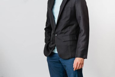 Tişörtlü, pantolonlu ve siyah ceketli bir adamın kırpılmış görüntüsü. Modern bir işadamının portresi.