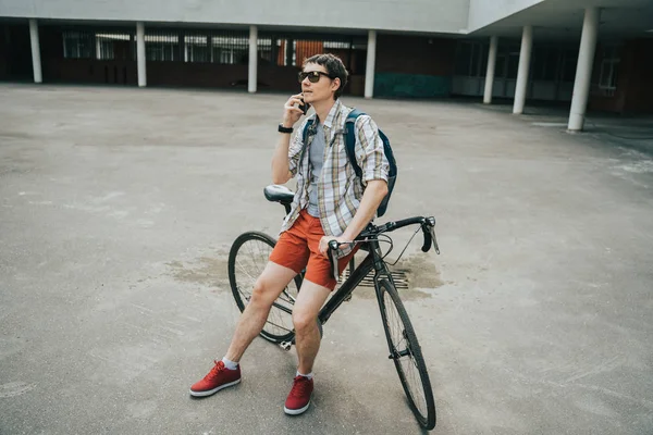 Homem posando ao lado de sua bicicleta . — Fotografia de Stock