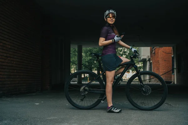 Donna in posa accanto alla sua bicicletta . — Foto Stock