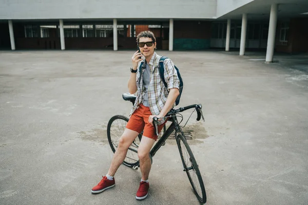 Homem posando ao lado de sua bicicleta . — Fotografia de Stock