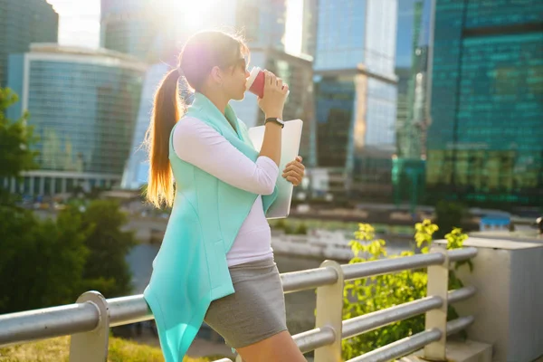 Retrato de mujer de negocios caminando con portátil y taza de café — Foto de Stock