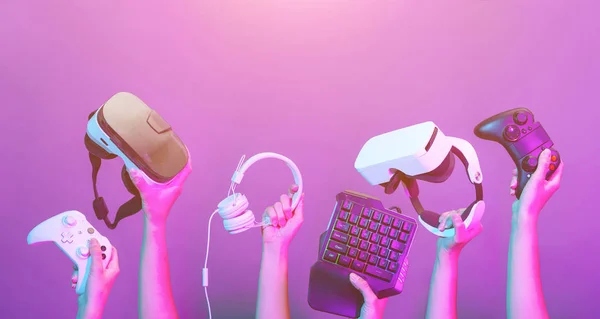 Set van handen met gamepad, toetsenbord, Virtual Reality headset en hoofdtelefoon op Violet achtergrond. — Stockfoto