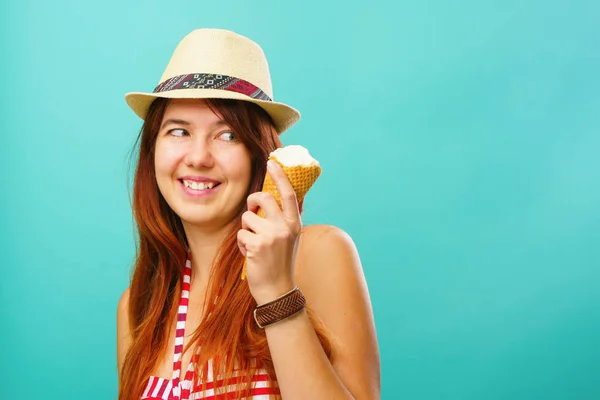 Mujer con un traje de baño y sombrero de paja come helado de la taza sobre fondo de color turquesa — Foto de Stock