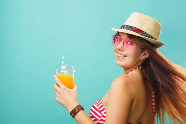 Mujer con traje de baño y sombrero bebe jugo de frutas de una taza — Foto de Stock