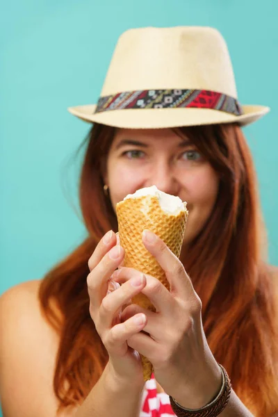 Mujer con un traje de baño y sombrero de paja come helado de la taza sobre fondo de color turquesa — Foto de Stock