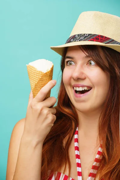 Mujer con un traje de baño y sombrero de paja come helado de la taza sobre fondo de color turquesa — Foto de Stock