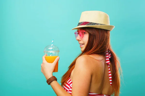 Mujer con traje de baño y sombrero bebe jugo de frutas de una taza — Foto de Stock