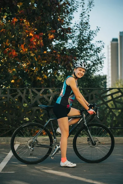 Zdjęcie na stronie młodej kobiety w kasku na przejażdżkę rowerem w letni dzień — Zdjęcie stockowe