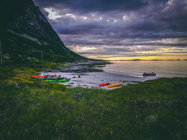 Foto de Noruega con mar, colina con cielo nublado, barcos de colores en verano al atardecer — Foto de Stock