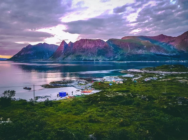 Foto de Noruega con mar, colina con cielo nublado, barcos de colores en verano al atardecer — Foto de Stock