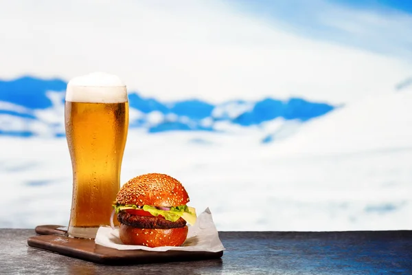 Copa helada de cerveza ligera con hamburguesa — Foto de Stock