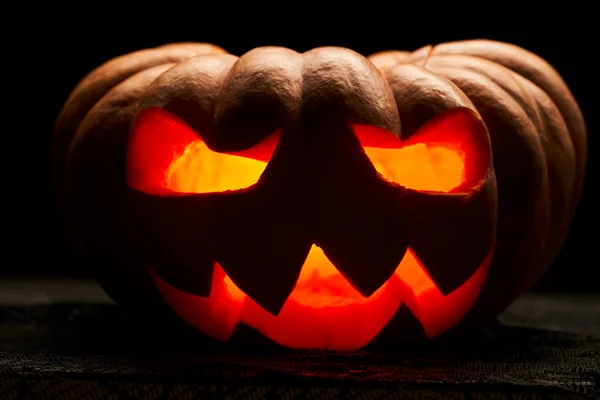 Feche a foto de uma abóbora de Halloween com bocas ardentes no fundo preto vazio — Fotografia de Stock