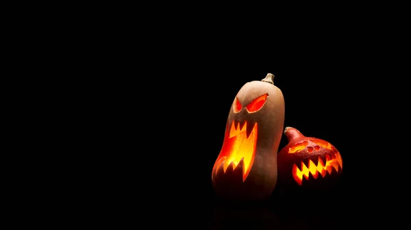 Foto van twee Halloween pompoenen met brandende monden op lege zwarte achtergrond in Studio. — Stockfoto