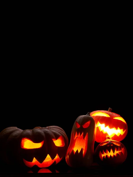 Foto de abóboras de Halloween com bocas ardentes em fundo preto vazio em estúdio — Fotografia de Stock