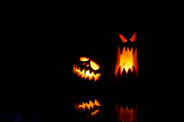 Foto de duas abóboras de Halloween com bocas ardentes em fundo preto vazio  . — Fotografia de Stock