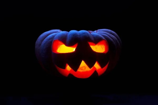 Image rapprochée d'une citrouille d'Halloween avec des bouches brûlantes sur fond noir vide — Photo