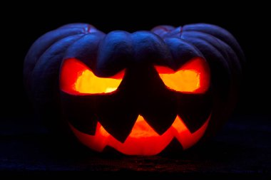 Boş siyah arka plan üzerinde yanan ağızları ile bir halloween kabak yakın görüntü