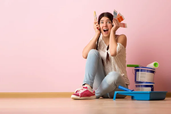 Mujer con pincel y paleta de colores sentada en el suelo — Foto de Stock