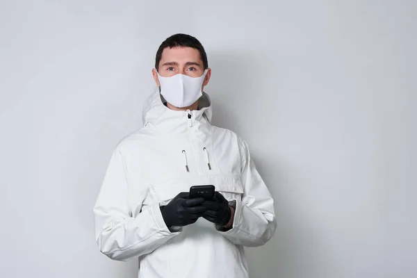 Людина в захисній масці, щоб запобігти поширенню Coronavirus комунікацій через смартфон. — стокове фото