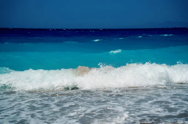 海岸、エーゲ海、ロードス島、ギリシャの穏やかな海の波の泡. — ストック写真