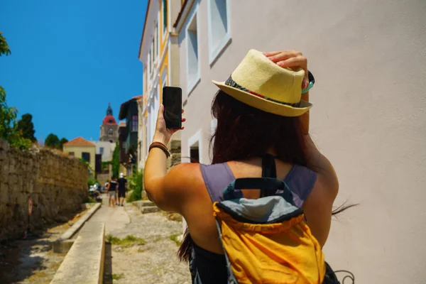 Mulher feliz viajante está andando e tirando foto selfie no telefone na ilha grega de Rodes, Dodecaneso, Grécia — Fotografia de Stock