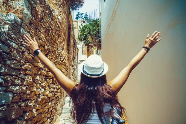 Parte de trás da jovem mulher viajante andando e olhando na ilha grega de Symi, Dodecaneso, Grécia . — Fotografia de Stock