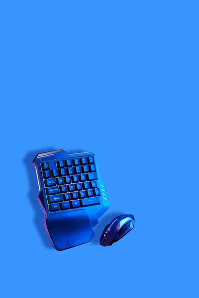 Games keyboard and mouse on blue background.