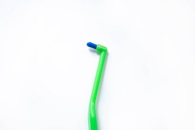 Beyaz arkaplandaki diş telleri için tek kirişli yeşil diş fırçası