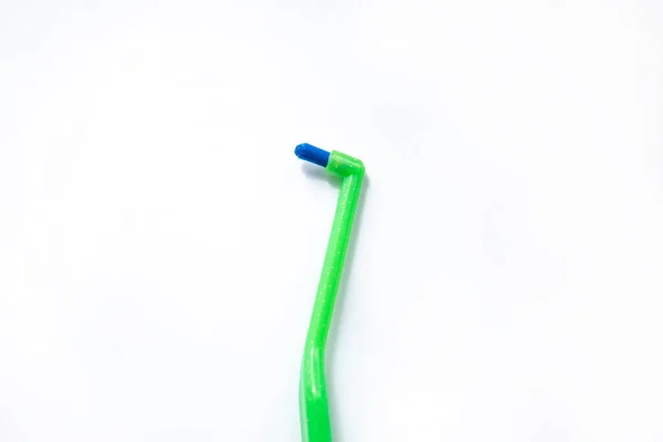 Sikat gigi hijau dengan satu balok untuk kawat gigi pada latar belakang putih Stok Foto Bebas Royalti