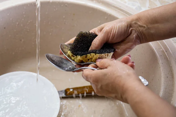 Tangan wanita mencuci sendok di wastafel dapur. Konsep rumah tangga — Stok Foto
