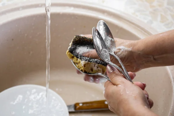 Tangan wanita mencuci sendok di wastafel dapur. Konsep rumah tangga — Stok Foto