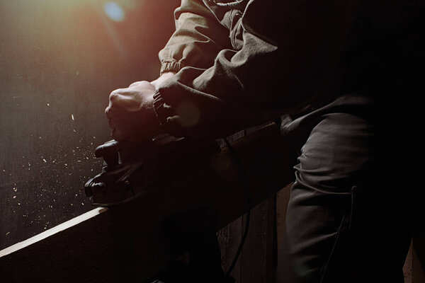 Фото рабочего в форме в голубых перчатках, работающего на черном фоне с верхним светом и боковым видом
.