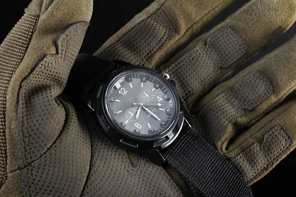 Brazo de soldado sosteniendo de cerca el reloj táctico negro . — Foto de Stock