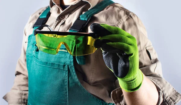 Pracovník v zeleném celkovém oblečení s brýlemi. — Stock fotografie