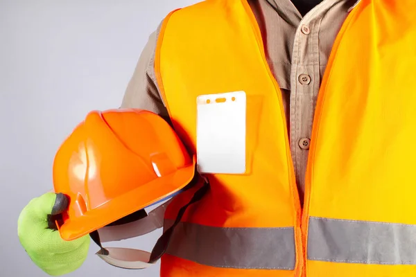 Werknemer in oranje jas outfit met helm closeup. — Stockfoto