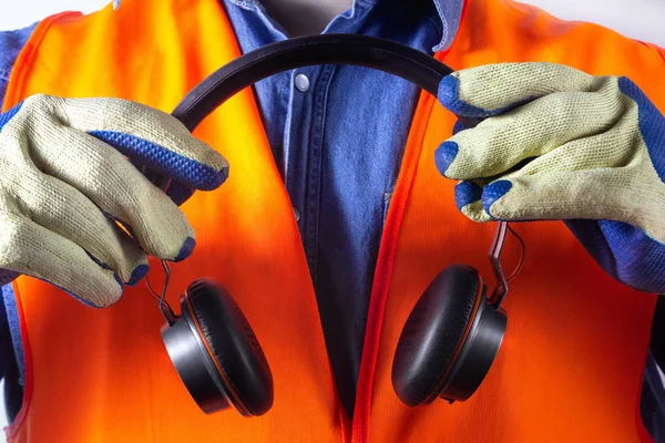 Trabajador en traje de chaqueta naranja con auriculares primer plano . — Foto de Stock