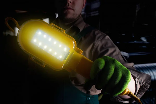 Trabajador en conjunto verde con lámpara . — Foto de Stock