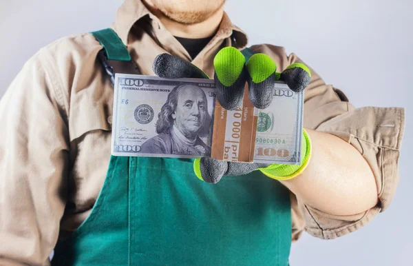 Foto di un operaio in abito verde in possesso di denaro . — Foto Stock