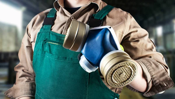 Trabalhador em roupa geral verde com respirador . — Fotografia de Stock