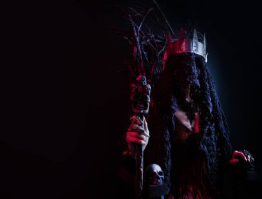 Dişi cadı kraliçe dallardan yapılmış tahtta oturuyor..