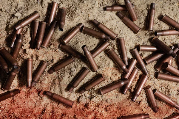 Pile of bloody rifle gun shells laying on battlefield. — Stock Photo, Image