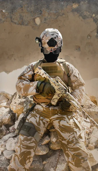 Soldat du désert assis dans une tranchée en pierre avec un mur fissuré . — Photo